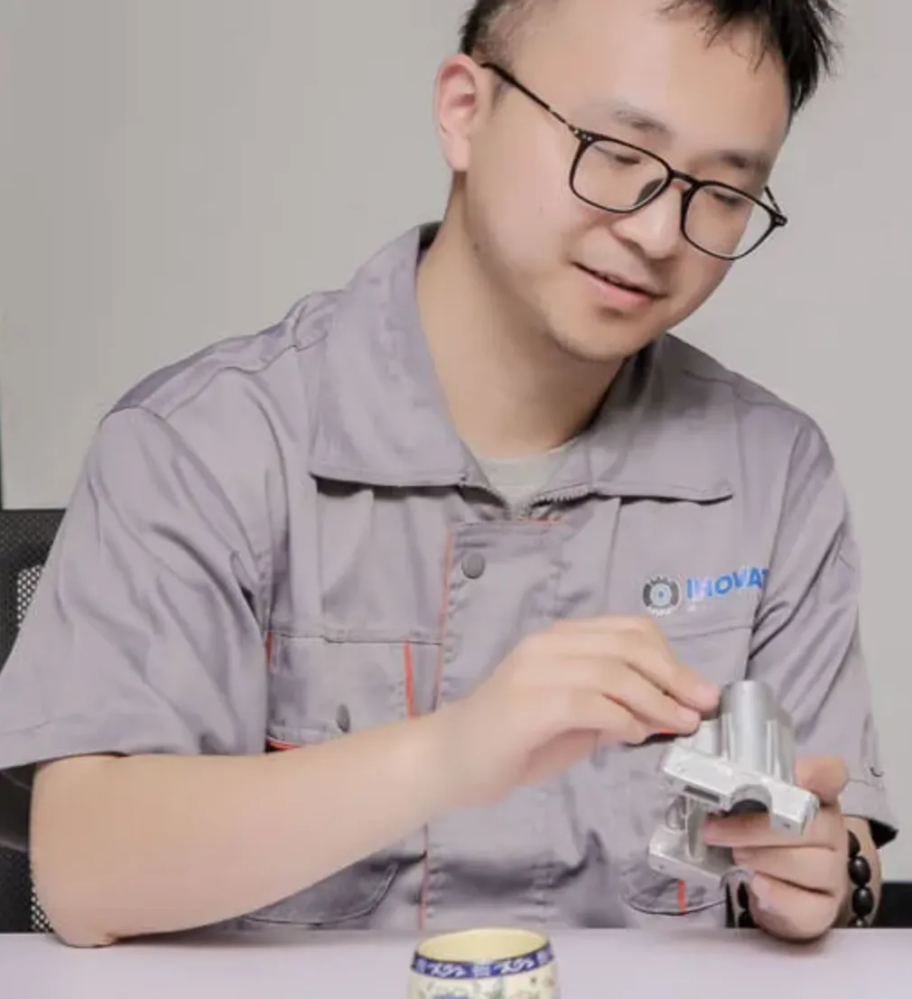 Earnest Zhang trabajando con componentes metálicos en el taller de Inovatec Machinery